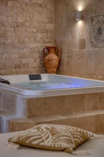 a bath tub with a vase sitting next to it at Appartement luxueux avec jacuzzi in Saint-Martin-dʼHères
