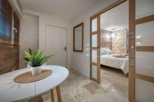 a room with a bed and a table with a potted plant at Appartement luxueux avec jacuzzi in Saint-Martin-dʼHères