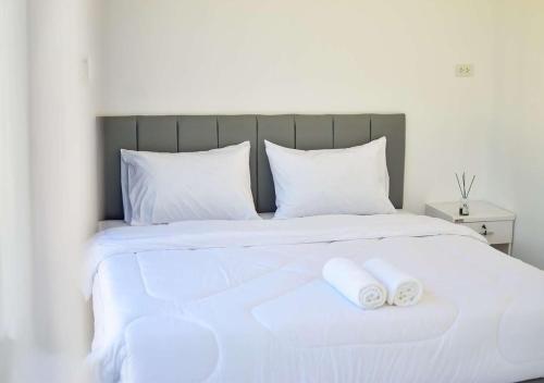 a white bed with two white towels on it at Koh Kood AYA Homestay in Ko Kood