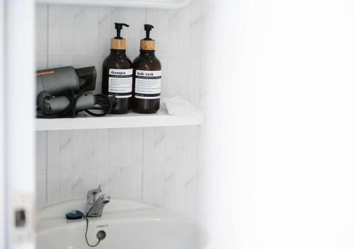 three bottles of wine sitting on a shelf above a sink at Koh Kood AYA Homestay in Ko Kood