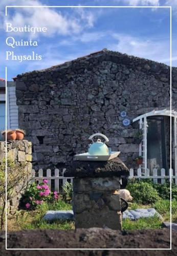 a stone building with a blue bowl on top of it at Boutique Quinta Physalis in Fenais da Luz