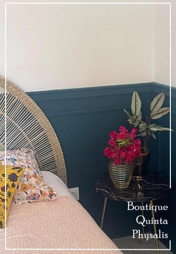 a bedroom with a table with a vase of flowers at Boutique Quinta Physalis in Fenais da Luz