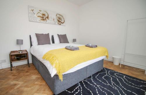 a bedroom with a large bed with a yellow blanket at The Lockett Wonderful Large Bungalow Plympton, Plymouth Free Parking By STAE-Homes in Plymouth
