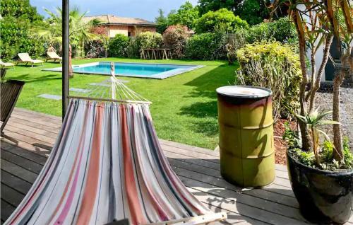 un jardin avec un hamac et une piscine dans l'établissement Awesome Home In La Teste-De-Buch, à La Teste-de-Buch