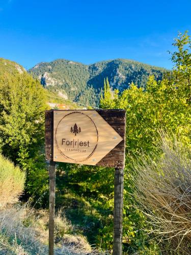 a sign for the front of a forest with mountains in the background at Forrest Guesthouse in Polídhroson