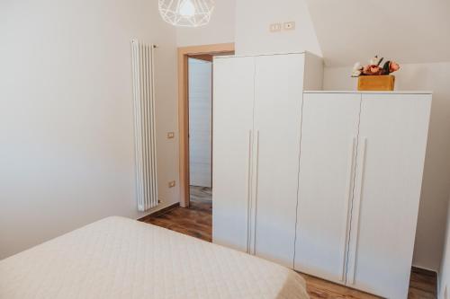 a bedroom with white cabinets and a bed at Agriturismo Angelino - Giazza Ljetzan in Selva di Progno