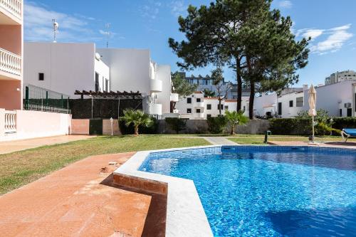 a swimming pool in the backyard of a house at Parque dos Reis Apartment in Monte Gordo
