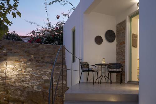 a patio with a table and chairs on a wall at Porto Sereno Andros Suites in Andros