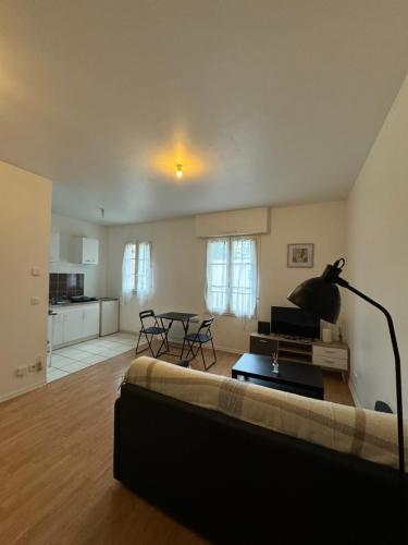 un salon avec un canapé et une table dans l'établissement Studio idéal Gare & Centre-Ville, à Conflans-Sainte-Honorine