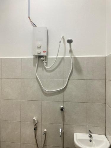 a bathroom with a shower head and a sink at Cerah Homestay in Kampong Gong Kempas