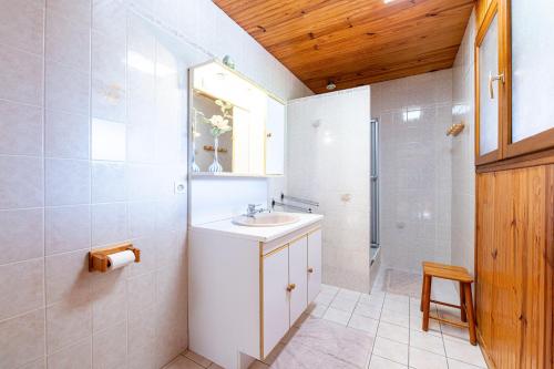 a white bathroom with a sink and a mirror at Gîtes Sambuy et Belle-Etoile in Seythenex