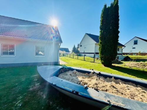 a boat in the water next to a house at Ferienhaus Usedom Familie Stopp Haus 21 in Lütow