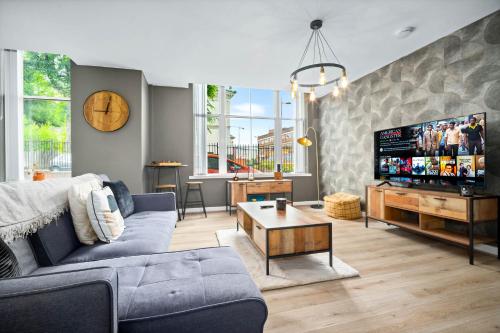 a living room with a blue couch and a tv at Luxe Apartment with Private Parking in Gated Complex - Close to JQ & City Centre - Top Rated - 7SH in Birmingham