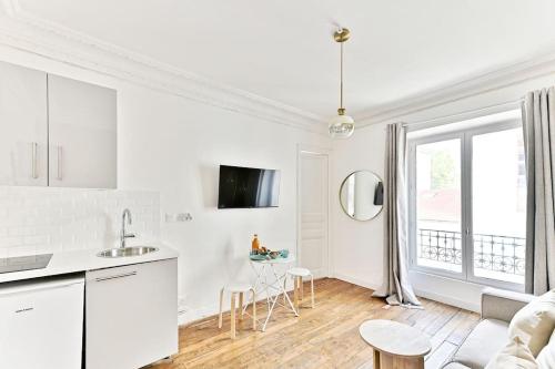 Cet appartement blanc comprend une cuisine et un salon. dans l'établissement Apartment next Tour Montparnasse - V, à Paris