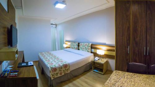 a hotel room with a bed and a tv at Laguna Plaza Hotel in Brasilia
