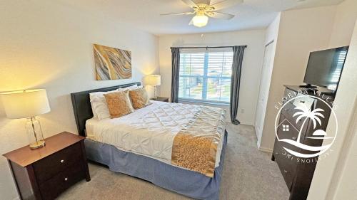 a bedroom with a bed and a flat screen tv at Villas Standard Seven Dwrafs Resort - Close to Disney in Kissimmee