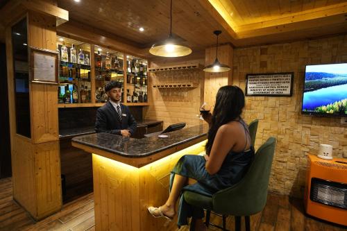 a man and a woman sitting at a bar at Mount Magnolia Boutique Hotel & Spa in Pelling