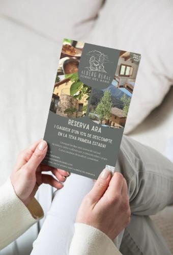 a person holding a book in their hands at Alberg rural torre del baró in Sant Llorenc de Morunys