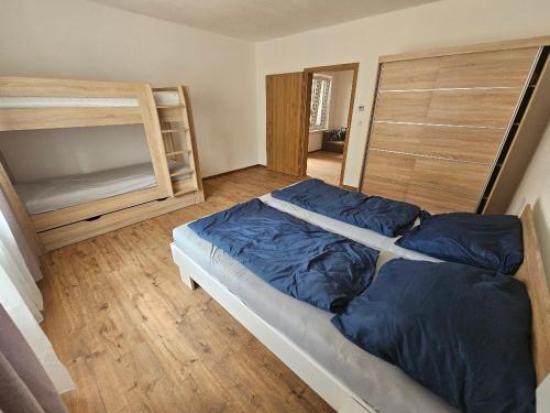 a bedroom with a bed and a wooden floor at U maďarčika in Prituľany