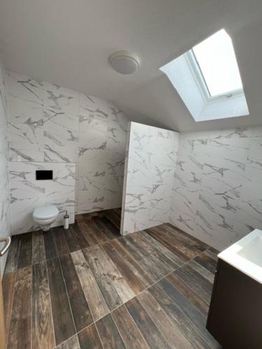 a bathroom with a toilet and a window on the wall at U maďarčika in Prituľany