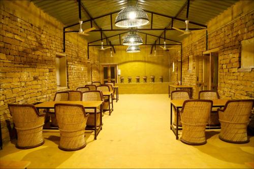 a room with tables and chairs and a brick wall at Vijay Bagh in Jaisalmer