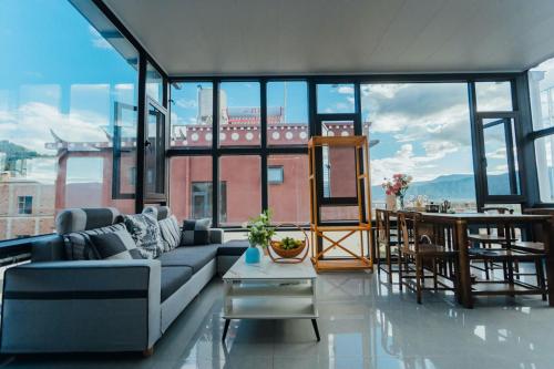 a living room with a couch and large windows at 云硕客栈 in Shangri-La