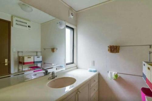 Un baño con lavabo y un espejo grande. en 大阪鶴橋, en Osaka