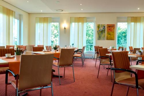 a dining room with tables and chairs and windows at Gasthof zum Bad in Langenau