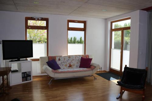 a living room with a couch and a flat screen tv at Stadtvilla in Murnau am Staffelsee