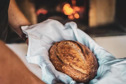 a person holding a piece of bread in a basket at Hercegasszony Birtok in Mezőtúr
