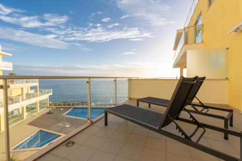 a balcony with a chair and a view of the ocean at Comfort & Style w/ best sea view in Sesimbra