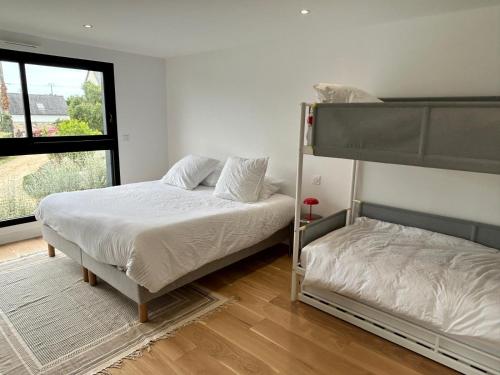 une chambre avec deux lits superposés et une fenêtre dans l'établissement Villa Poppy - piscine, proche plage, à Roscoff