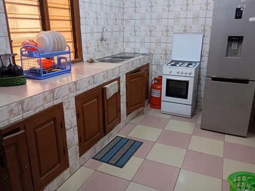 una cucina con lavello, fornello e frigorifero di Jrodait appart a Cotonou
