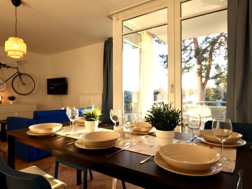 a dining room table with plates and wine glasses at Modern Apartment Near Kristalltherme- MontiRooms in Ludwigsfelde