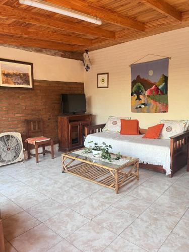 a living room with a bed and a tv at Departamento Uschi in Los Hornillos