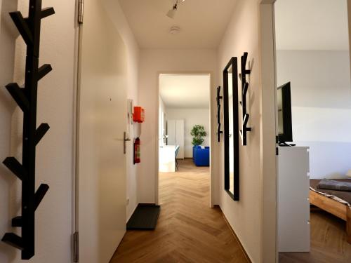 a hallway with black sculptures on the wall in a apartment at Modern Apartment Near Kristalltherme- MontiRooms in Ludwigsfelde