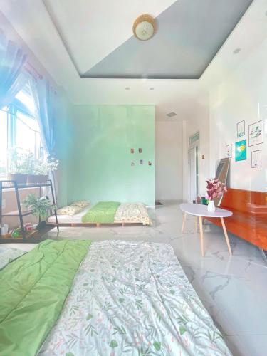 a bedroom with a large bed and a table at Nhà của Nâu - Homestay Đà Lạt in Da Thanh