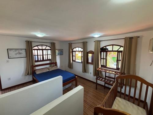 a bedroom with a bed and two windows at Casa Becker - Praia Seca in Araruama