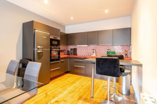 a kitchen with a glass table and a refrigerator at Bel appartement dans le centre historique avec wi-fi et toutes les commodités in Dinan