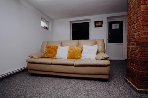 a couch with two pillows on it in a room at Casa ANSI in Sărămaş