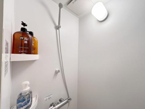 a bathroom with a shower and a bottle of soap at 晴の松 in Wakayama