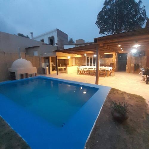 a large blue swimming pool in front of a house at Estación Tilcara boutique hotel in Tilcara