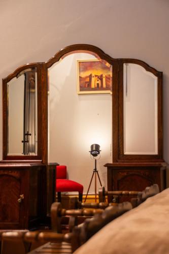 a bedroom with a mirror and a red chair at Estación Tilcara boutique hotel in Tilcara