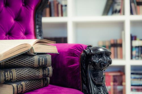 a pile of books sitting on top of a couch at Hercegasszony Birtok in Mezőtúr