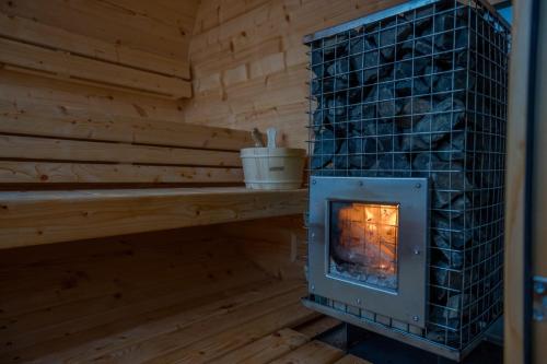 a wood burning stove in a sauna at Rajska polana Domki PREMIUM ,na odludziu z prywatną BALIĄ z jacuzzi i sauną ,Cisza,rowery elektryczne,góry,astroprzygoda,- Adršpach, Skalne Miasto, Zamek Książ,Andrzejówka,Karpacz, Śnieżka,Janskie Laznie,Pec in Mieroszów