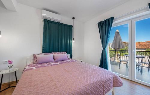a bedroom with a pink bed and a balcony at House Seaside Magnolias in Pirovac