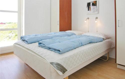 a bed with blue pillows on it in a room at Holiday Home Stikkelsbærvej Tarm Iv in Hemmet