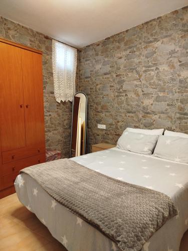 a bedroom with a bed and a brick wall at Apartamento Plano Royo 2º in Villahermosa del Río