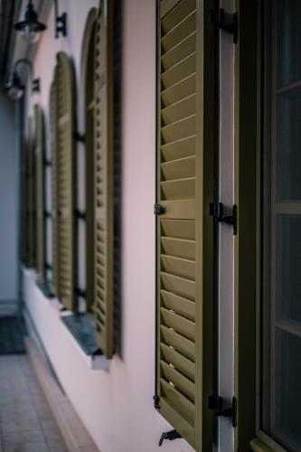 a row of green shuttered windows on a building at Hercegasszony Birtok in Mezőtúr