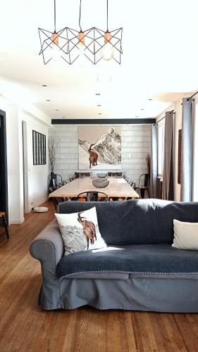 a living room with a blue couch and a table at Sublime Chalet 14 Pers Spa Extrieur in Cauterets
